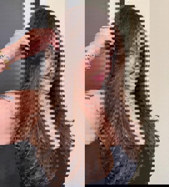 Ciepły kasztan z długimi warstwami i delikatną grzywką okalającą twarz Ciepły kasztan z długimi warstwami i delikatną grzywką okalającą twarz